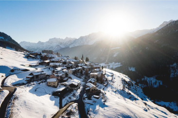 Luftaufnahme von verschneitem Bündner Bergdorf
